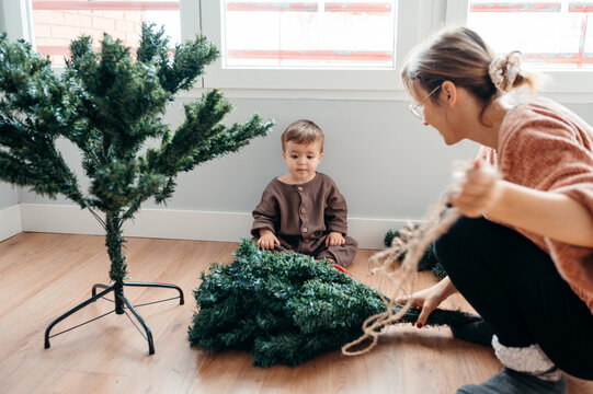 Mom and child assembling Christmas tree