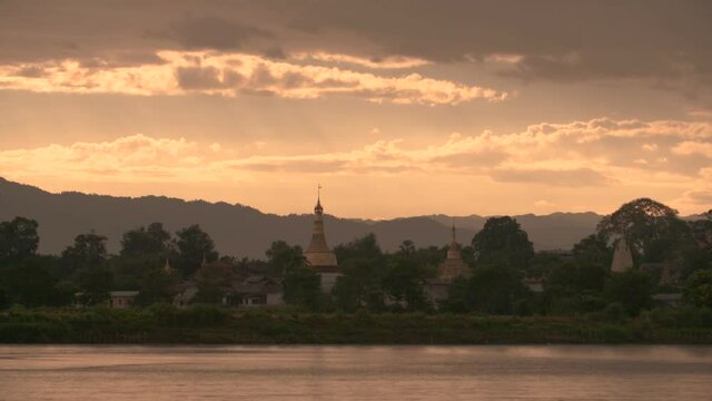 Dusk in Myanmar Countryside at the Irrawaddy River with Temple and Mountains Calm Scenery