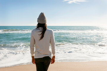 long hair man back view walking on the beach