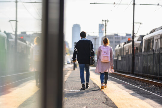 African American Couple Walking away on train platform in Boston  - Powered by Adobe