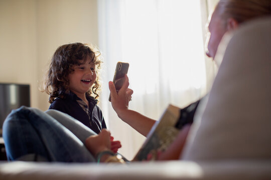 Young mother showing a smartphone to her 3 year old son