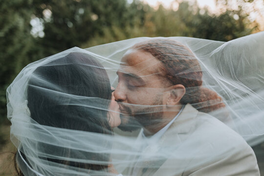 Bride and Groom Kissing under Veil