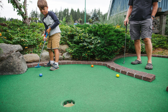 Boy putts on minigolf green