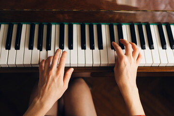 Woman fingers playing piano keyboard