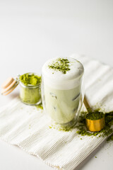 Matcha green tea latte with ice cubes on the white background
