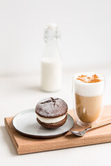 Glass of coffee latte with whoopie pie cream dessert