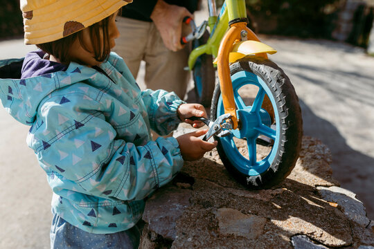 little girl and her father fixing a bicycle