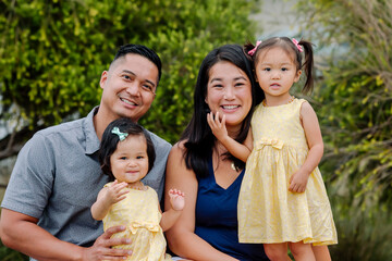 Happy asian family with two daughters outdoors