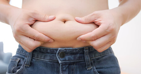Naklejka premium hand pinch excessive belly fat