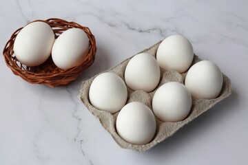 Cardboard egg rack with white eggs on white background. six Hen eggs tray. White Chicken Eggs in a wooden bowl. online shopping product photography. copy space.  