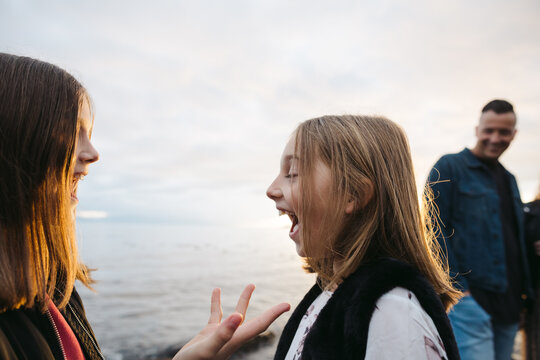 Two girls having fun together at sunset yelling