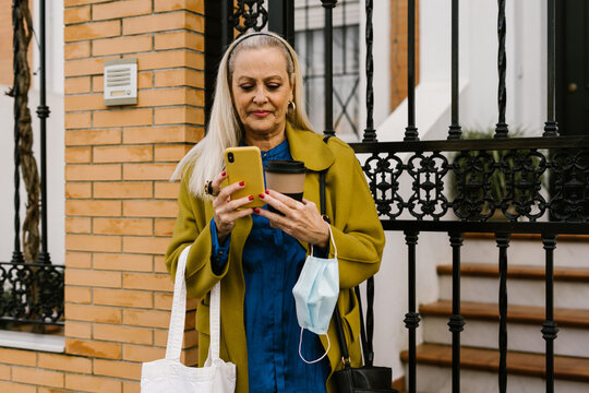 Senior Woman Using Her Phone At Street