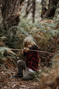 boy aiming with bow and arrow