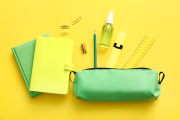 Pencil case with stationery on color background