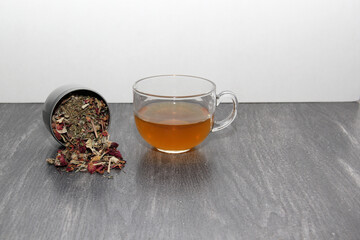 Tea making tools: glass cup, infuser, sachets, dried dehydrated herb, spoon, to relax and cure...