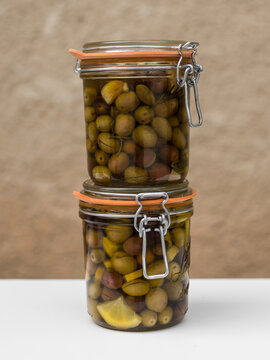 Pile of glass jars with preserved homemade pickled olives