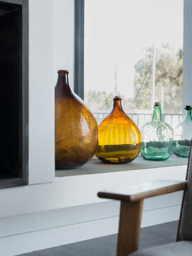 Vintage glass storage vases, bottles or jars placed by a window