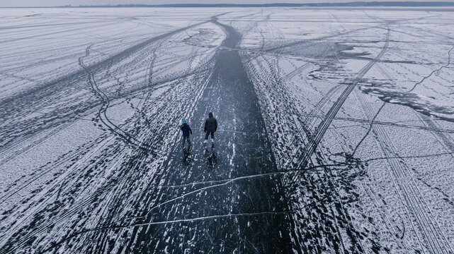 Father and son ice skating on the frozen river