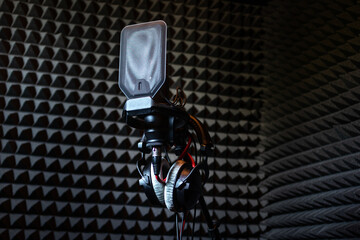 Professional studio condenser microphone in recording studio with studio headphones on a sound...