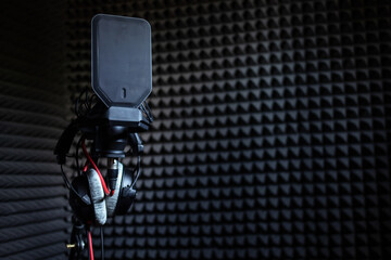 Professional studio condenser microphone in recording studio with studio headphones on a sound...