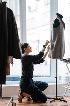 Serious dressmaker sewing clothes in workshop