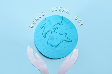 Text WORLD OCEAN DAY with paper planet Earth and hands on color background