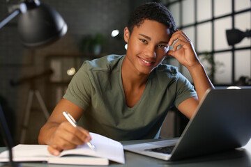 African-American student preparing for exam at home late in evening