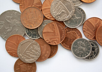 Group of English pound coins on a white background. Silver and copper colored coins of Great...