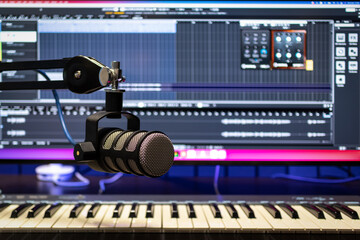Professional studio condenser microphone in modern music recording studio with computer screen...