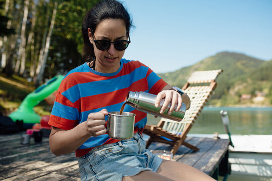Woman Pouring Coffee At The Lake