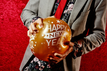 smashing a balloon that reads happy new year