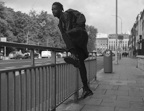 Man Jumping a Fence on the Street