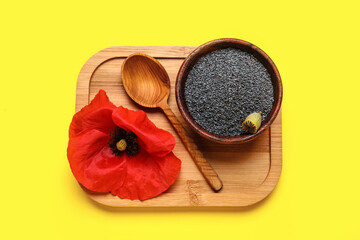 Bowl with poppy seeds and flower on color background