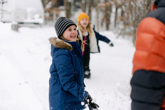 young girl throwing a  snowball on her dad 