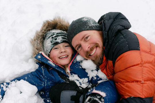 father and daughter having fun in the snow