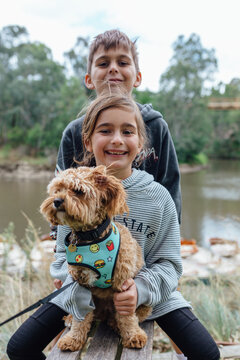 Brother and sister posing with their doge