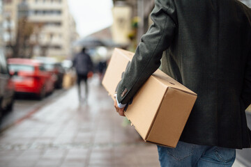 Anonymous man carrying a box
