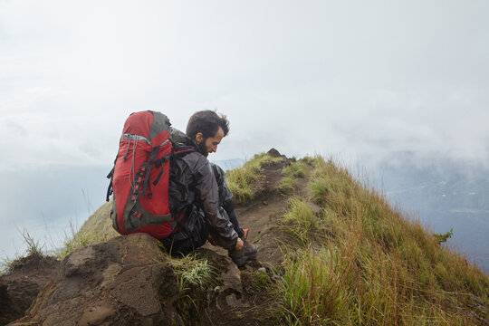 A man with a backpack on the mountain during a halt