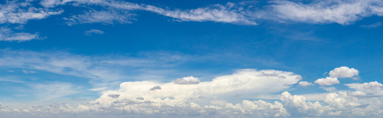Obraz premium blue sky background with tiny clouds. panorama white fluffy clouds in the blue sky.Beautiful vast blue sky with amazing cloud background.Wide sky panorama with scattered cumulus clouds.