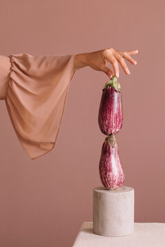 Woman's Hand Holding a Graffiti Eggplant