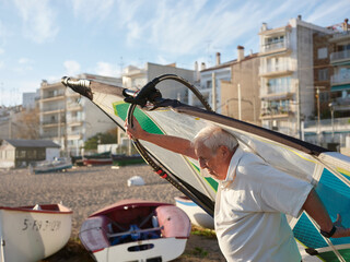 Aged man with windsurf sail