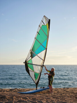 Aged sportsman ready for windsurf