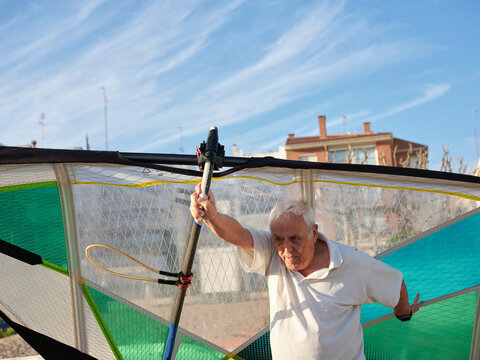 Aged man with windsurf sail