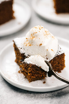 Fork Cutting into A Gingerbread Cake with Whipped Cream