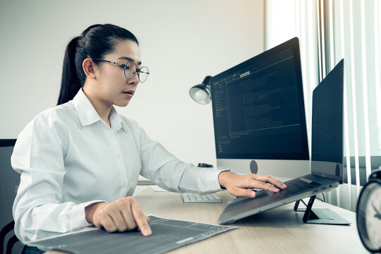 Software developers are analyzing about the code written into the program on the computer in office room.