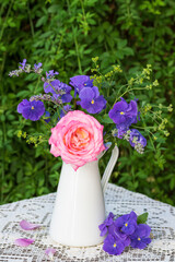 Blumenstrauß mit Rose und Hornveilchen im vintage Krug