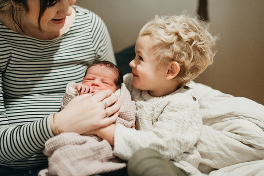 brother meeting new born sister for the first time