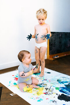 Brother and sister enjoying some messy painting 