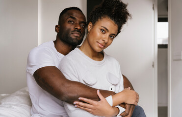 Loving black couple hugging at home
