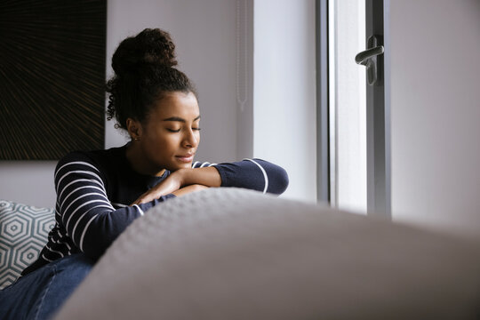 Tender black woman resting on sofa